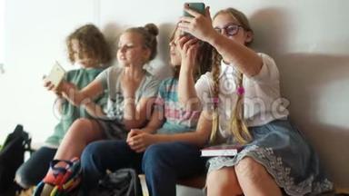 一群青少年坐在学校走廊里，拍一张集体自拍。 孩子和小玩意